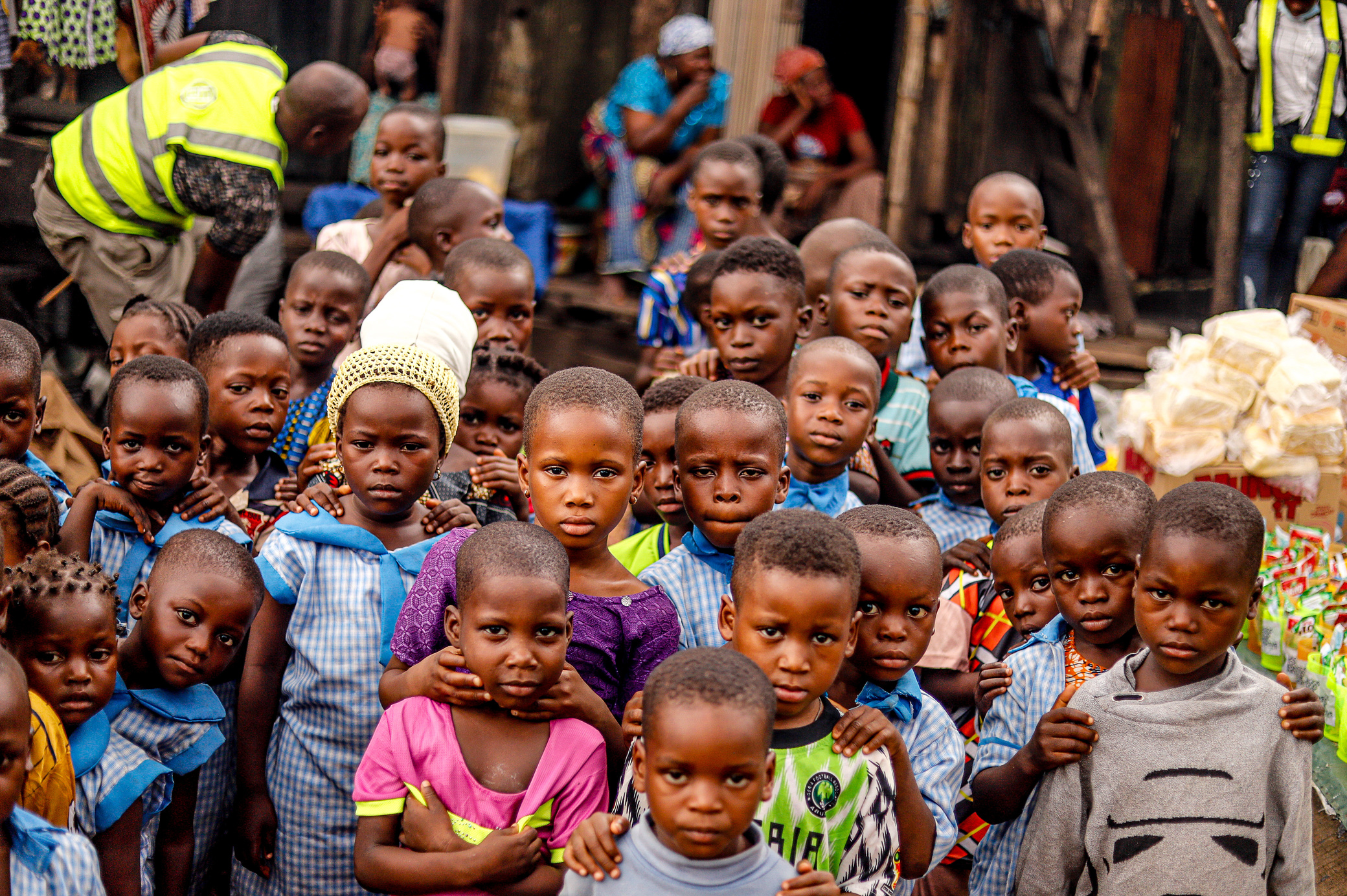 African Children Posing for a Photo with an Aid Worker in Background